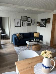 奥勒松Light home apartment Alesund with free parking的客厅配有蓝色的沙发和桌子