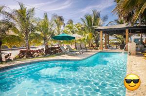 下维加Ocean Front Villa, 2 Private Pools, BBQ, Tennis court and more!的一个带海滩遮阳伞和黄色球的游泳池