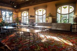 旧金山绿乌龟青年旅舍的一间设有桌椅的餐厅,位于带窗户的房间内