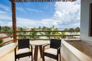 艾库玛尔Secrets Akumal Riviera Maya - Adults Only的一个带桌子和两把椅子的海景阳台