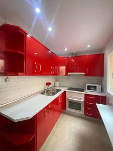 雷阿尔城La Florida的红色的厨房,配有白色家电和红色橱柜