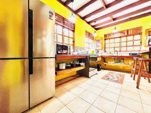 别霍港Casa Elita - Tranquil Escape with Pool, Jacuzzi, AC的厨房设有黄色的墙壁和不锈钢冰箱。