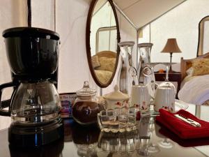 PaoniaCosmo Glamping Tent at Zenzen Gardens的一张桌子、咖啡壶和玻璃杯