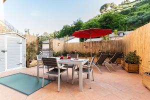波托菲诺Portofino's Little Nest [Wi-Fi & A/C]的庭院配有桌椅和遮阳伞。