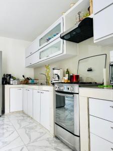 卡塔赫纳Le MARIE B&B的厨房配有白色橱柜和烤箱。