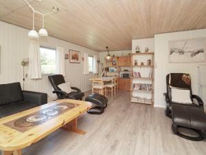 伊斯科博约格6 person holiday home in Eskebjerg的客厅配有木桌和椅子