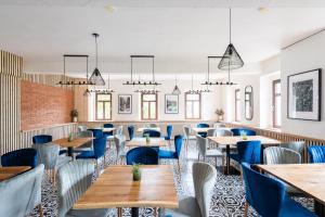 赫日布斯卡Penzion Mezi buky的餐厅设有木桌和蓝色椅子
