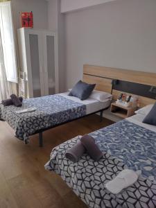 圣地亚哥－德孔波斯特拉Pensión Casa Douro的配有两张床的客房内。