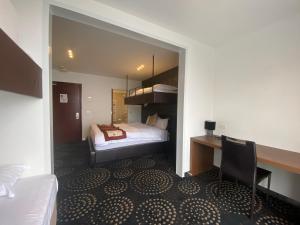 布勒山布勒山杜克旅馆的酒店客房带一张床铺、一张书桌和一间卧室
