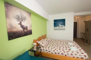 布加勒斯特Studio Moghioros rezidence 2的卧室配有一张床,墙上挂有绘画作品