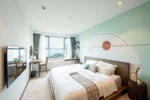 头顿THE SONG VŨNG TÀU - Five-Star Luxury Apartment - Căn Hộ Du Lịch 5 Sao Cạnh Biển的一间卧室配有一张大床和一张书桌