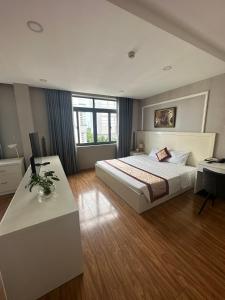 Vị ThanhKhách sạn Hậu Giang的一间卧室配有一张大床和一张书桌,