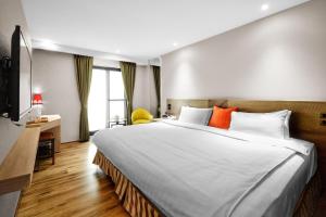 嘉义市兰桂坊花园酒店的卧室配有带橙色枕头的大型白色床