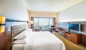 曼谷Royal Orchid Sheraton Hotel and Towers的配有一张床和一台平面电视的酒店客房