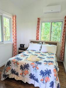 罗阿坦West Bay Roatan - Sunny & Modern Oasis- 2 Bedrooms - 3 min walk to beach的一间卧室配有一张蓝色和橙色床罩的床