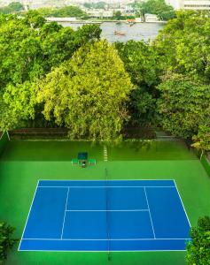 曼谷Royal Orchid Sheraton Hotel and Towers的享有带树木的网球场的顶部景致