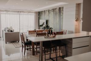 莫塞尔湾View @ The Bay Apartments 9的厨房以及带桌椅的用餐室。