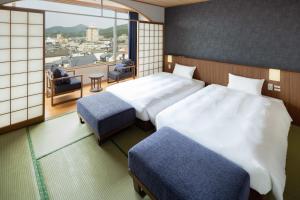 嬉野市Hotel Sakura Ureshino的酒店客房设有两张床和一个阳台。