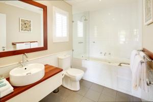 亚林加普亚林加普贝壳酒店的浴室配有盥洗盆、卫生间和浴缸。