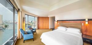 曼谷Royal Orchid Sheraton Hotel and Towers的一间酒店客房,设有一张大床和一个大窗户