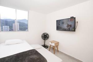 萨瓦内塔Apartamento Medellin-sabaneta a cuadra del metro的白色客房 - 带两张床和平面电视