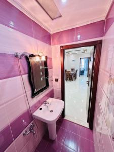 拉腊什Abraj Dubai Larache的粉红色的浴室设有水槽和镜子