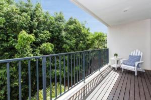 悉尼Stylish parkside retreat的阳台配有椅子和桌子,种有树木