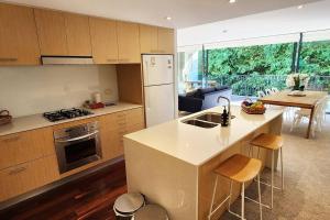 悉尼Stylish parkside retreat的厨房配有水槽和炉灶 顶部烤箱