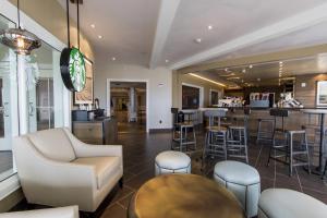 桑达斯基杉树角热浪酒店的餐厅内的酒吧,设有凳子和柜台