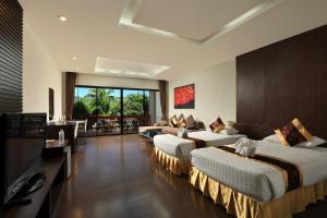 拉威海滩Rawai Grand House -SHA Plus的酒店客房,设有两张床和一张沙发