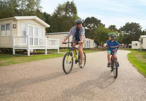 HumberstonSpacious Caravan - Thorpe Park Cleethorpes的骑车的男人和孩子