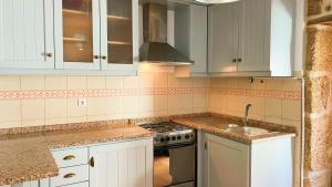 科维良Casa de Partida的厨房配有白色橱柜和水槽