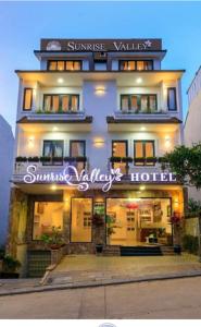 大叻Sunrise Valley Dalat Hotel的一座建筑,上面有读到日出时分的标志