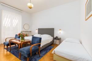 法扎纳Brijuni Rooms Karmen的酒店客房带一张床、一张桌子和椅子