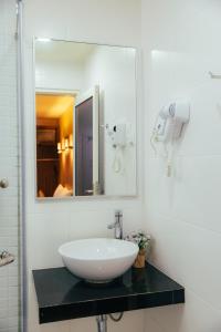 关丹Hotel Sentral Kuantan @ Riverview City Centre的一间带水槽和镜子的浴室