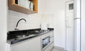 里约热内卢Tabas Lindo apê 2 quartos em Copacabana CP0005的白色的厨房设有水槽和炉灶。
