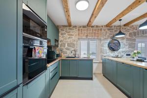 HreljinVilla Green Garden的厨房配有蓝色橱柜和石墙