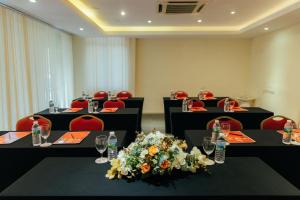 关丹Hotel Sentral Kuantan @ Riverview City Centre的一间会议室,配有黑桌和红色椅子