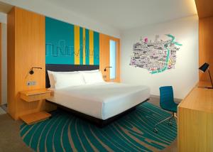 迪拜Aloft Dubai Creek的一间卧室配有一张床、一张桌子和一把椅子