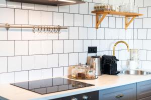 奥洛穆茨Silvie Apartments - Masaryk的一个带水槽和白色瓷砖墙壁的厨房台面