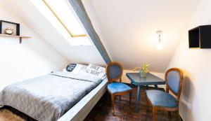 奥洛穆茨Silvie Apartments - Masaryk的卧室配有一张床和一张桌子及椅子