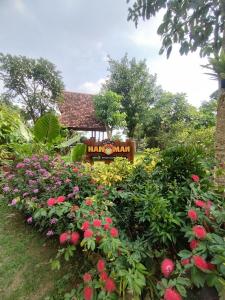 PablenganKebun Hanoman Villa的花在标志前的花园