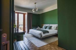 科莫Gaby Lake Suites的一间卧室设有绿色的墙壁、一张床和窗户