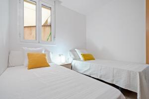 L'AldeaSara的带2扇窗户的客房内的2张床