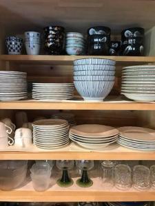 Inashikiビラ里山双林的装满盘子、碗和盘子的架子