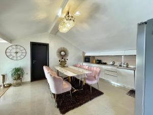 斯韦蒂·斯特凡Apartments Kentera LUX的一间带桌子和粉红色椅子的用餐室