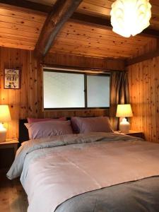 Inashikiビラ里山双林的一间卧室配有一张大床和两盏灯