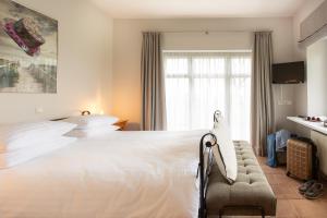 霍尔斯泰因地区奥尔登堡Landhotel Teichwiesenhof, Bed&Breakfast的卧室设有一张白色大床和一扇窗户。