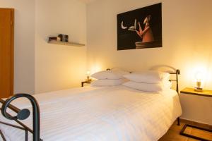 霍尔斯泰因地区奥尔登堡Landhotel Teichwiesenhof, Bed&Breakfast的一间卧室配有带白色床单和枕头的床。