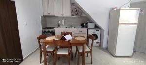 沃丽曼村Xenonas "Alexandra's Coffee House"的厨房配有桌椅和冰箱。